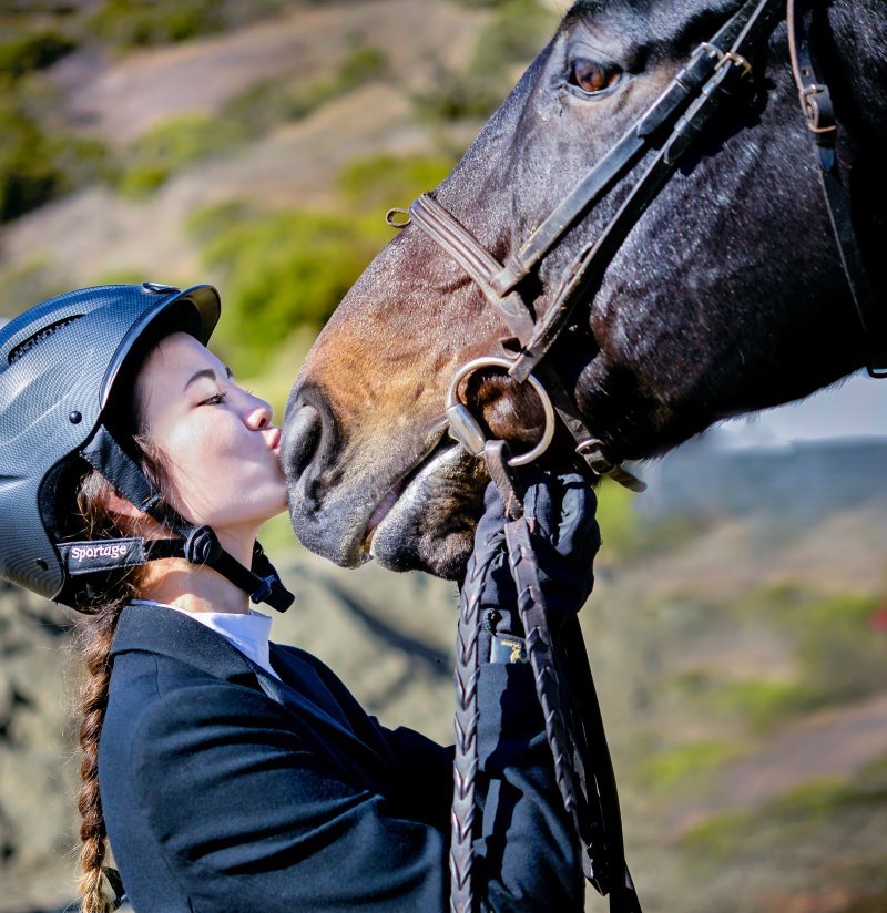 Turnierjacket-Trägerin küsst Pferd